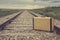 Vintage suitcase in middle of railroad tracks on the prairies