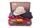 Vintage suitcase overstuffed with a summer hat