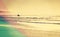 Vintage summer beach with surfer in the water