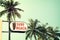 Vintage surf beach signage and coconut palm tree on tropical beach blue sky