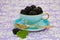 Vintage tea cup with black berries