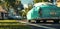 Vintage teal automobile parked on a sunny suburban street, evoking a sense of 1950s nostalgia.