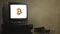 Vintage television on wood table with bitcoin. Old TV showing bitcoin. Near the TV there are film cassettes and video