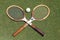 Vintage Tennis rackets and antique white tennis ball on grass tennis court.
