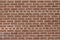 Vintage textured reddish brown brick wall in common bond pattern