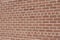 Vintage textured reddish brown brick wall in common bond pattern