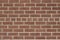 Vintage textured reddish brown brick wall in common bond pattern