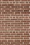 Vintage textured reddish brown brick wall in common bond pattern