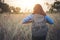 Vintage tone images of beautiful young hipster woman with backpack walking on meadow. Portrait of hiker girl outdoor.