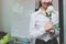 Vintage toned image of cheerful young Asian business woman holding a white roses in office on Valentine`s day. Love and romance i