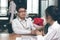 Vintage toned image of cheerful young Asian woman accepting a bouquet of red roses from boyfriend with envious angry woman backgro