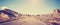 Vintage toned panoramic photo of desert road.