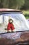 Vintage toned photo of the old bear toy on the retro rusty car outdoors