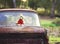 Vintage toned photo of the old bear toy on the retro rusty car outdoors