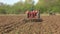 Vintage tractor pulling a harrow.