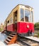 Vintage tram with wooden stairs near open doors located on rails on sunny day on town street