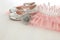 Vintage tulle pink chiffon dress, crown and silver shoes on wooden white floor