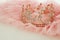 Vintage tulle pink chiffon dress and diamond tiara on wooden white table. Wedding and girl& x27;s party concept