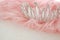 Vintage tulle pink chiffon dress and diamond tiara on wooden white table. Wedding and girl& x27;s party concept