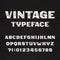 Vintage typeface. Retro alphabet font. Type letters and numbers on a rough wooden background.