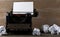 Vintage typewriter with empty, blank sheet of paper and crumbled