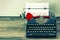 Vintage typewriter with white page and red rose flower