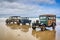 vintage vehicle collection on pristine beach, with waves rolling in