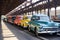 vintage vehicles of different colors in a row on the platform