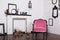 Vintage velor armchair, in a bright room and an artificial fireplace. Interior attic with wooden white walls. Picture frames on th