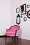 Vintage velor armchair, in a bright room. Various empty picture frames with a skull and antlers hanging on a wooden wall. The conc