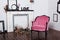 Vintage velor armchair, in a bright room. Various empty picture frames with a skull and antlers hanging on a wooden wall. The conc