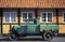 Vintage veteran retro green oldtimer pickup truck car and timbered house