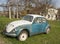 Vintage volkswagen beetle car rusting in the backyard in a villa