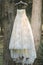 Vintage wedding gown hangs from a tree