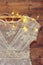 Vintage white crochet lace top on hanger with garland lights on wooden background