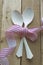 Vintage white spoons, pink ribbon on wooden background
