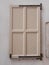 Vintage white wooden window. Antique building exterior detail. Street photo. Retro wood beige boards