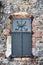 Vintage window with black iron shutter and stone wall