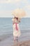 Vintage woman on beach with parasol