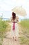 Vintage woman with parasol at the beach