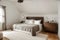 Vintage wooden cupboard next to king size bed with pillows and blanket in trendy bedroom interior