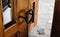 Vintage wooden door with antique forged metallic round handle closeup