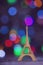 Vintage wooden Eiffel Tower with garland lights on colorful bokeh background