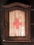 Vintage wooden first aid kit cabinet with glass door and red cross sign