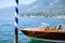 Vintage wooden motorboat parked by venetian pole on shore of the lake light reflecting from motorboat surface
