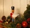 Vintage wooden Nutcracker, and glass ballerina figure, among holiday Christmas evergreens,