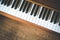 Vintage wooden piano. Keys in the foreground, wooden floor with text space in the blurry background