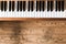 Vintage wooden piano. Keys in the foreground, wooden floor with text space in the blurry background