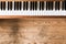 Vintage wooden piano. Keys in the foreground, wooden floor with text space in the blurry background