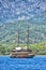 Vintage wooden pirate schooner in the open ocean against the background of the sea horizon. Tourist cruises in the Mediterranean